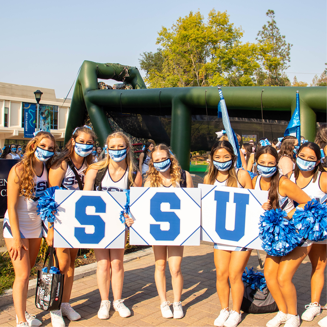 Cheer holding up ssu signs