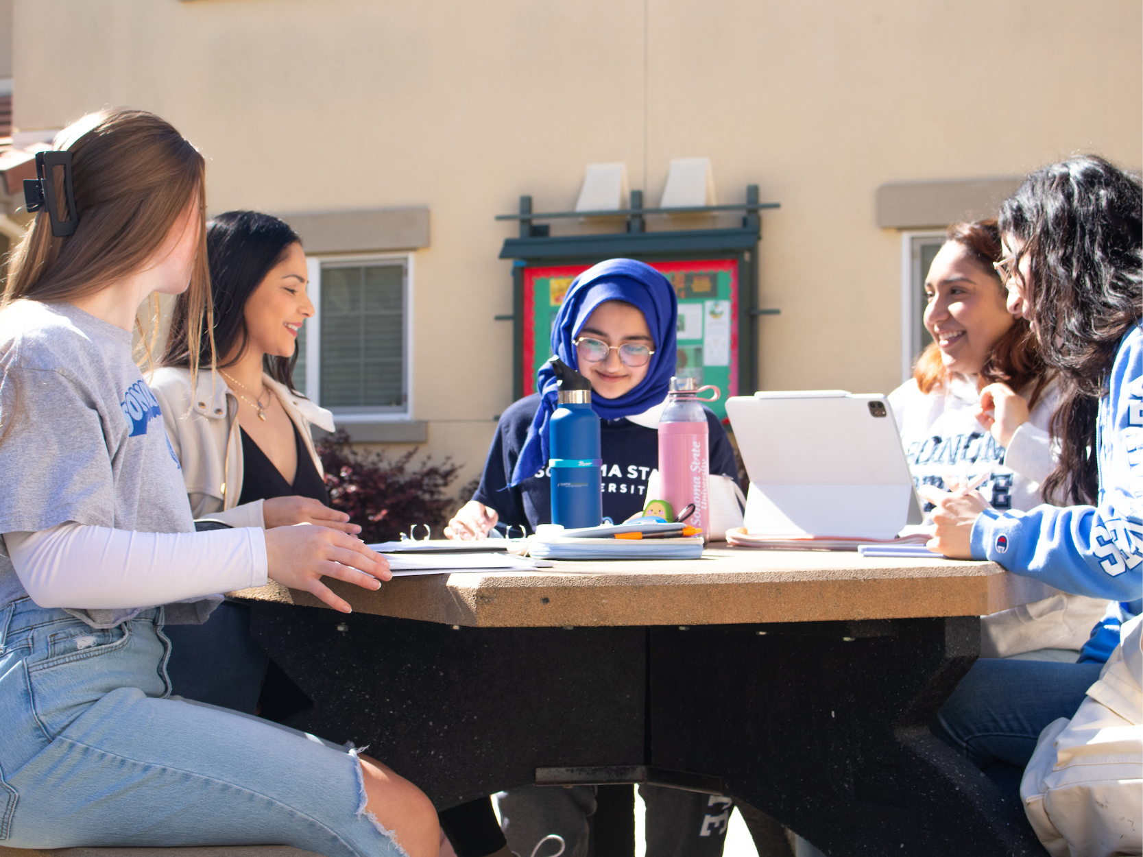 Students sitting at a tabling studying