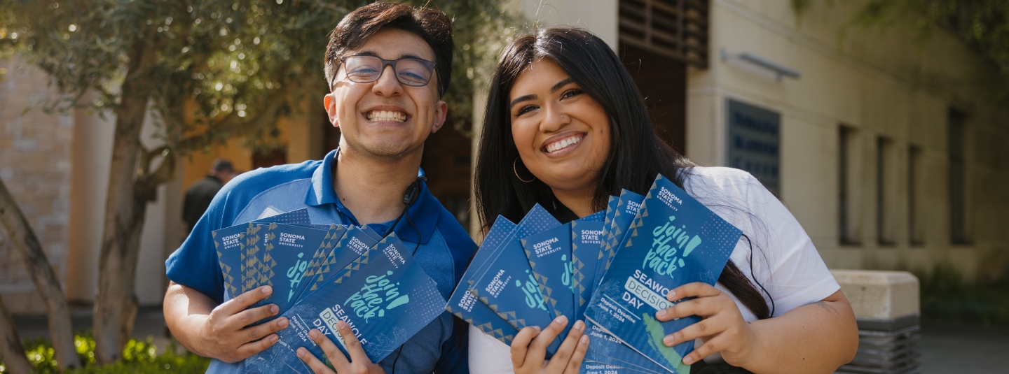 Two students holding up flyers for Join the Pack