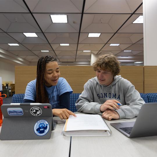 2 students reading at the library