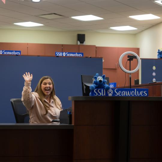Counselor waving at student
