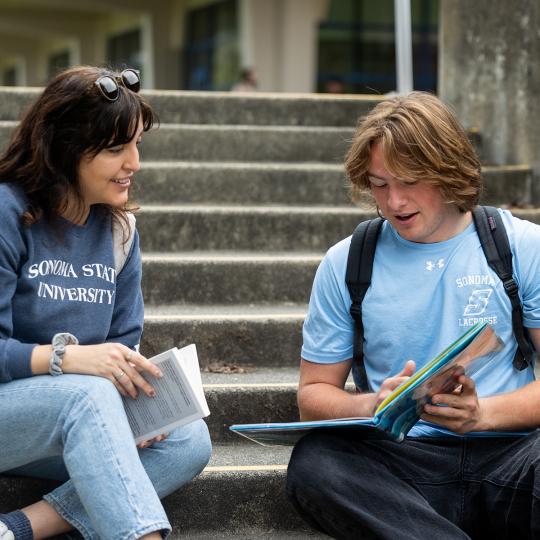 couple of students reading at the stairs