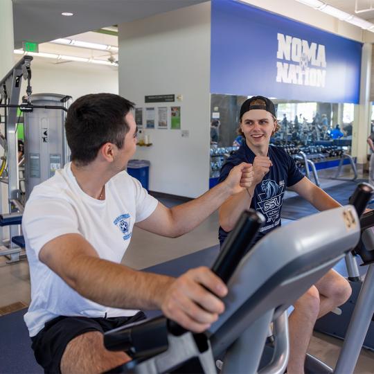 2 students working out together at the rec center