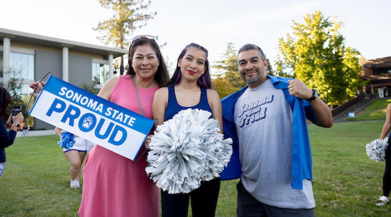 Two parents and a student holding Sonoma State Proud sign