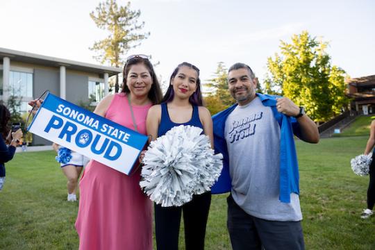 Two parents and a student holding Sonoma State Proud sign